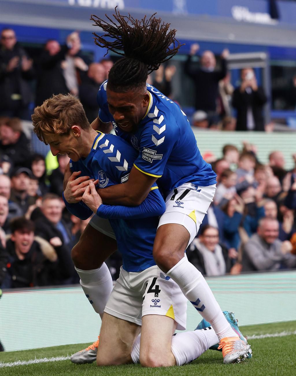 Alex Iwobi celebrates with goalscorer Anthony Gordon