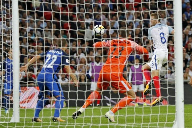 England's midfielder Eric Dier (R) shoots past Slovakia's goalkeeper Martin Dubravka to score on September 4, 2017