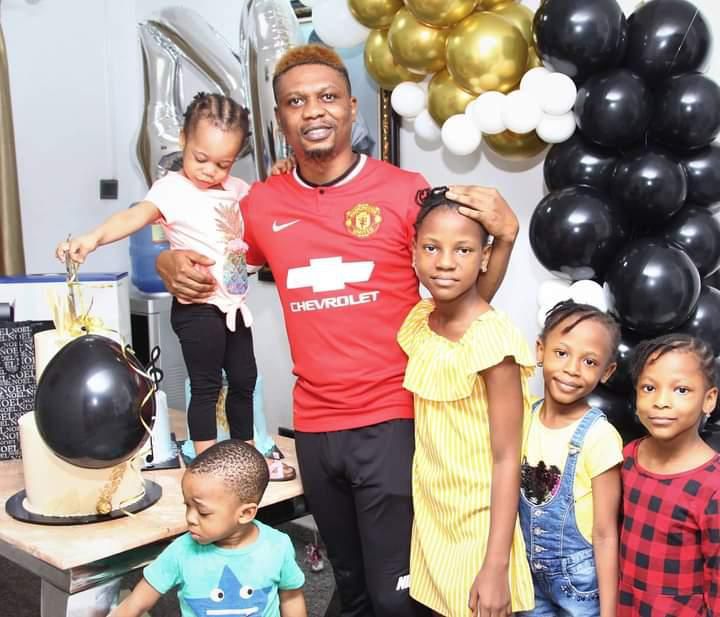 Reminisce celebrating his 40th birthday with his family by wearing a Manchester United jersey
