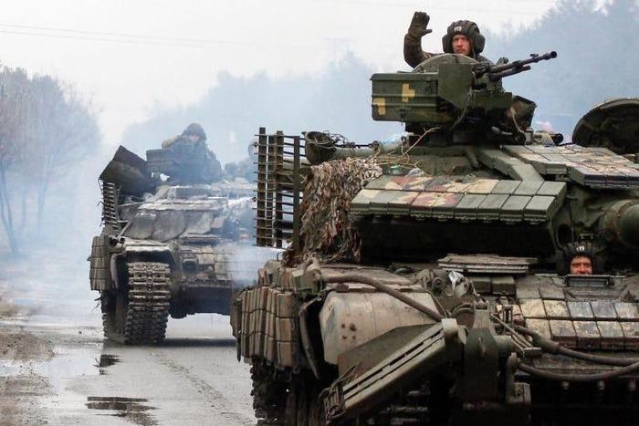 Ukrainian servicemen ride on tanks towards the front line with Russian forces in the Lugansk region of Ukraine on February 25, 2022