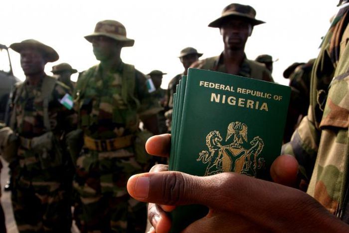 A Nigerian officer holds passports for his troops preparing to board a U.S. military plane in the Nigerian capital of Abuja