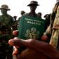 A Nigerian officer holds passports for his troops preparing to board a U.S. military plane in the Nigerian capital of Abuja