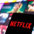 The Netflix logo is displayed on a smartphone screen.