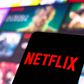 The Netflix logo is displayed on a smartphone screen.