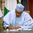 President Muhammadu Buhari signing (Premium Times)