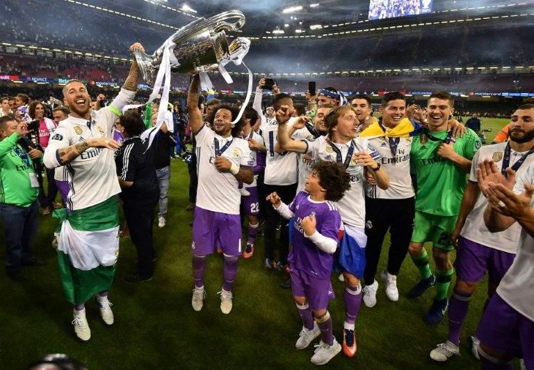 Real Madrid players hold the trophy after winning the UEFA Champions League final match against Juventus, at The Principality Stadium in Cardiff, south Wales, on June 3, 2017