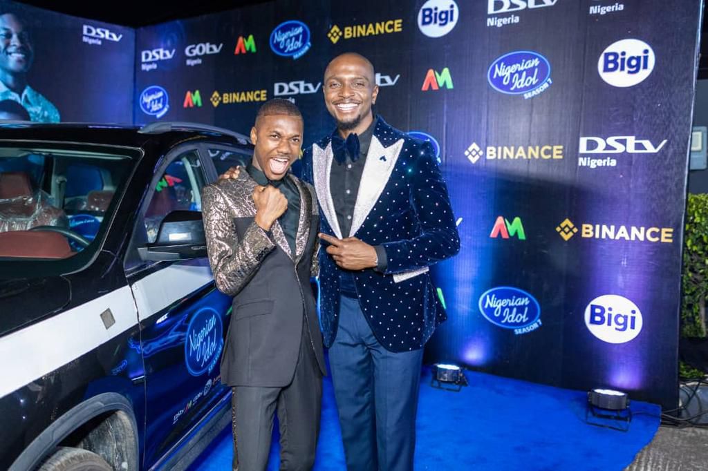 Progress Chukwuyem, winner of the Nigerian Idol Season 7, with a brand-new Sports Utility Vehicle (SUV), as part of the N100,000,000 (One Hundred Million Naira) worth of prizes won; IK Osakioduwa, the show’s host, at the grand finale of the music reali...