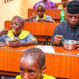 Vice President Yemi Osinbajo dining with beneficiaries of school feeding programmes (FMIC)