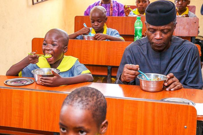 Vice President Yemi Osinbajo dining with beneficiaries of school feeding programmes (FMIC)
