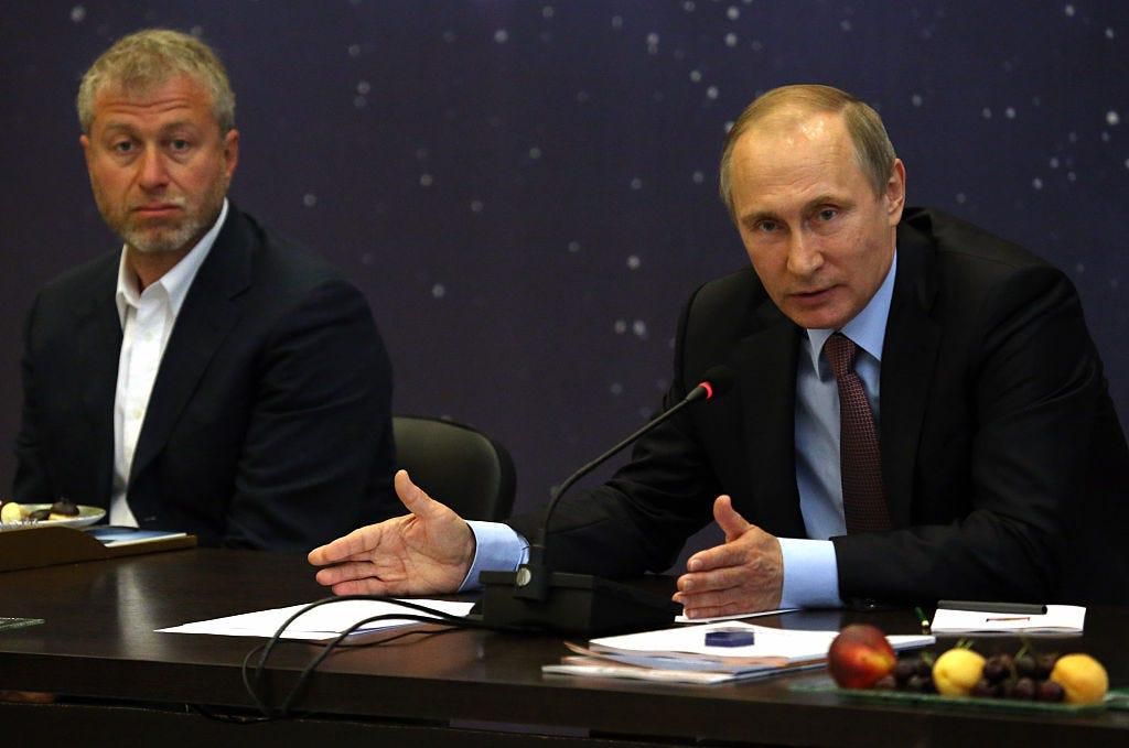 Russian President Vladimir Putin (R) speaks as billionaire and businessman Roman Abramovich (L) looks on during a meeting with top businessmen.