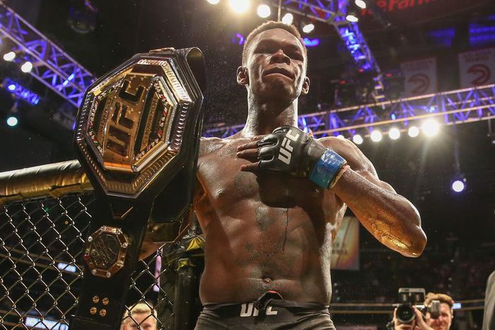 UFC Middleweight Champion Israel Adesanya hoists his belt.