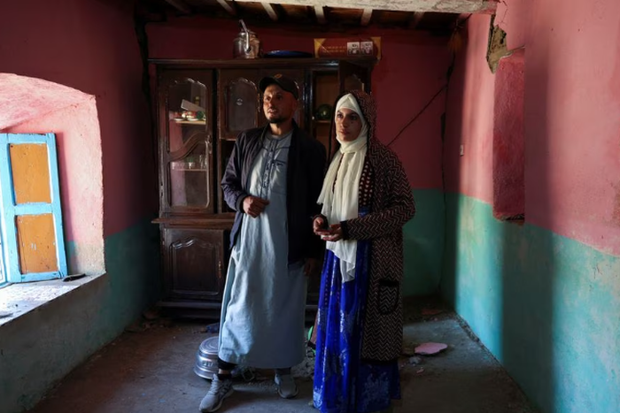 Groom Mohammed Boudad stands with his wife, Habiba Ajdir, inside their house that was damaged in the aftermath of the 6.8 magnitude earthquake, in Kettou village, Morocco September 12, 2023. [REUTERS/Emilie Madi]