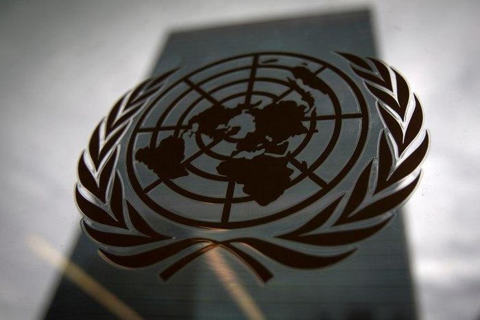 The United Nations headquarters building is pictured though a window with the UN logo in the foreground in the Manhattan borough of New York August 15, 2014.    REUTERS/Carlo Allegri