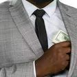 Black man hiding cash [Freepik]