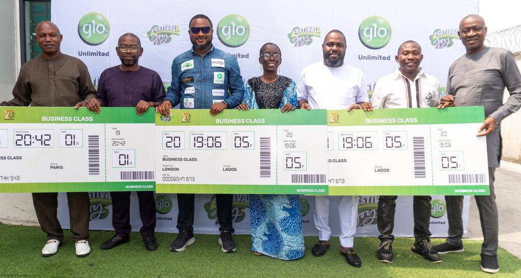(L-R) Delta State Coordinator, National Lottery Regulatory Commission, Mr. Awhara Innocent; Business Class Ticket winner, Mr. Abimbola Fasoranti; Glo Regional Manager, Warri, Mr. Fredrich Oiboh; Business Class Ticket winner, Mrs Elizabeth Chukwujekwu; ...