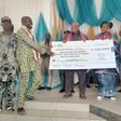 Gov. Adeleke presenting cheque to one of the communities representatives.