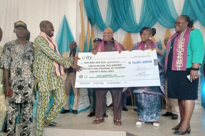 Gov. Adeleke presenting cheque to one of the communities representatives.