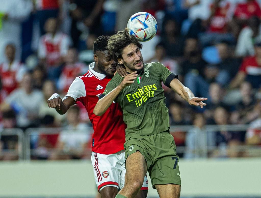 Football - Dubai Super Cup 2022 - Arsenal FC v AC Milan DUBAI, UNITED ARAB EMIRATES - Tuesday, December 13, 2022: Arsenal s Thomas Partey (L) challenges for a header with AC Milan s Yacine Adli during the Dubai Super Cup 2022