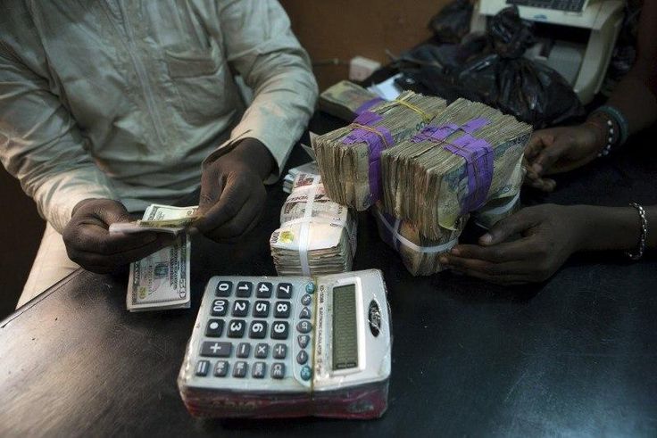 A trader changes dollars with naira at a currency exchange store in Lagos, Nigeria in this February 12, 2015 file photo.