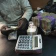 A trader changes dollars with naira at a currency exchange store in Lagos February 12, 2015.
