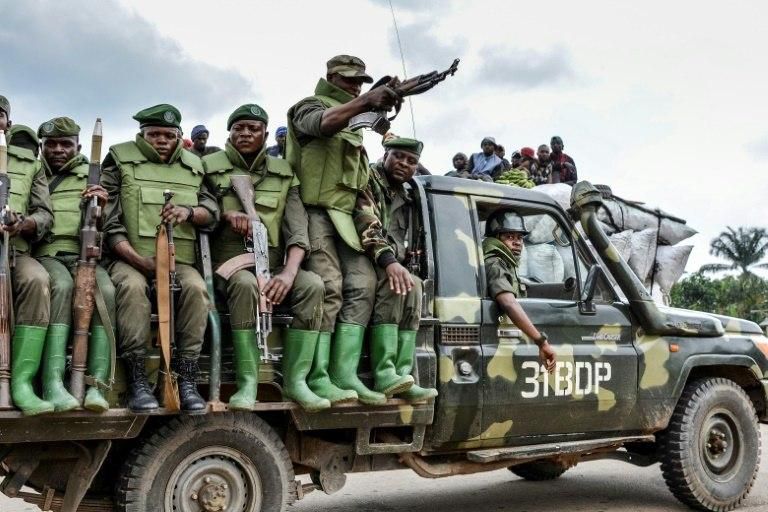Soldiers of the Armed Forces of the Democratic Republic of Congo sit on a military vehicle in an area of clashes with the ADF militia in Opira, North Kivu, on January 25