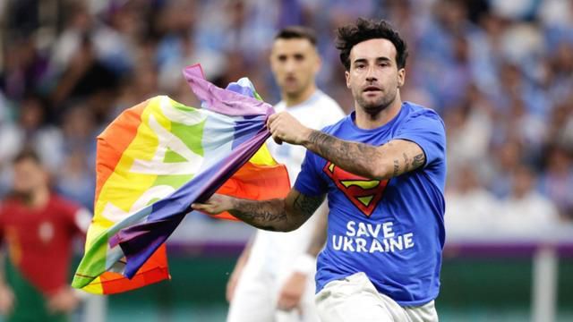 The pitch invader carried a rainbow flag over the fence at the World Cup
