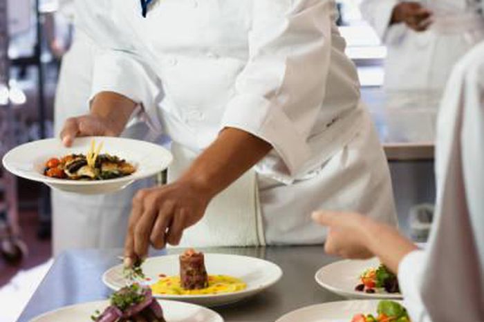A chef garnishing a meal