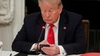 Former President Donald Trump uses a mobile phone during a roundtable discussion on the reopening of small businesses in the State Dining Room at the White House in Washington, US, June 18, 2020.