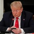 Former President Donald Trump uses a mobile phone during a roundtable discussion on the reopening of small businesses in the State Dining Room at the White House in Washington, US, June 18, 2020.