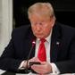 Former President Donald Trump uses a mobile phone during a roundtable discussion on the reopening of small businesses in the State Dining Room at the White House in Washington, US, June 18, 2020.