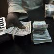 A trader changes dollars with naira at a currency exchange store in Lagos February 12, 2015.   REUTERS/Joe Penney