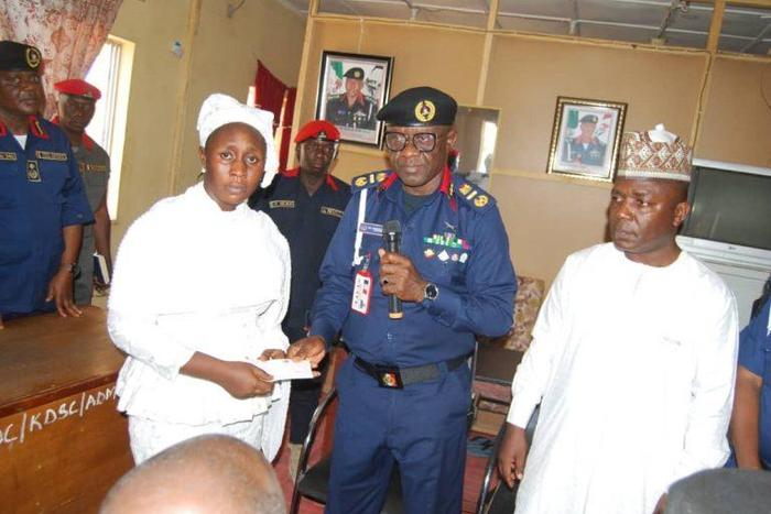 The Representative of Commandant General NSCDC presenting cheque to one of the next of kin on Thursday in Kaduna.
