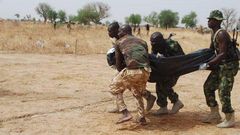 Nigerian soldiers carrying a fallen colleague.