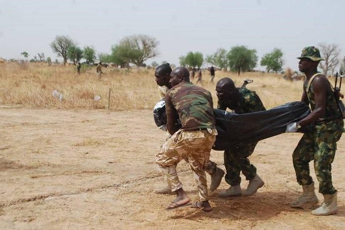 Nigerian soldiers carrying a fallen colleague.