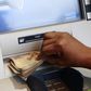 A woman takes Nigerian Naira from a bank's automated teller machine (ATM) in Ikeja district in the commercial capital Lagos November 12, 2014. REUTERS/Akintunde Akinleye.