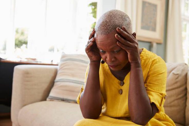 Distraught woman holds head in hands (image used for illustration) [iStock]