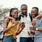 A group of black people checking out a phone [Freepik]