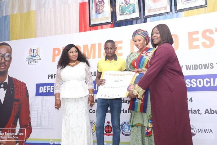 The President of DEPOWA, Mrs Oghogho Musa, presenting land document donated by Promiseland Estate to one of the beneficiaries in Abuja on Saturday (13/1/24)Donation [NAN]