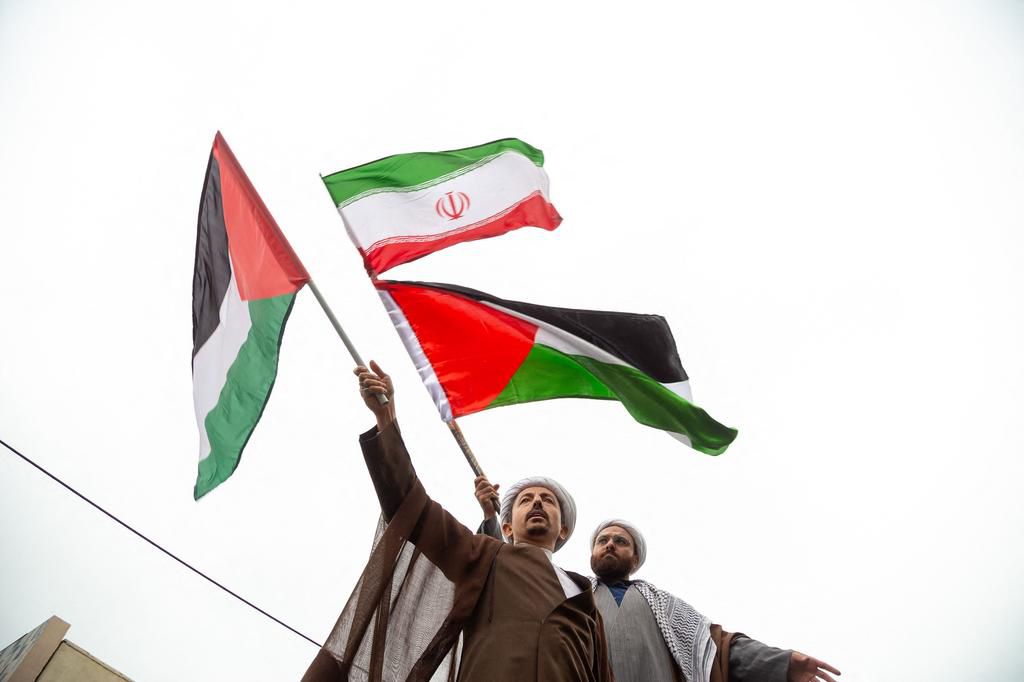 Tehran, Iran. In Tehran's capital, two Iranian clerics express their support by holding the flags of the Islamic Republic of Iran and Palestine as they take part in an anti-Israeli rally.HOSSEIN BERIS/Middle East Images/AFP via Getty Images