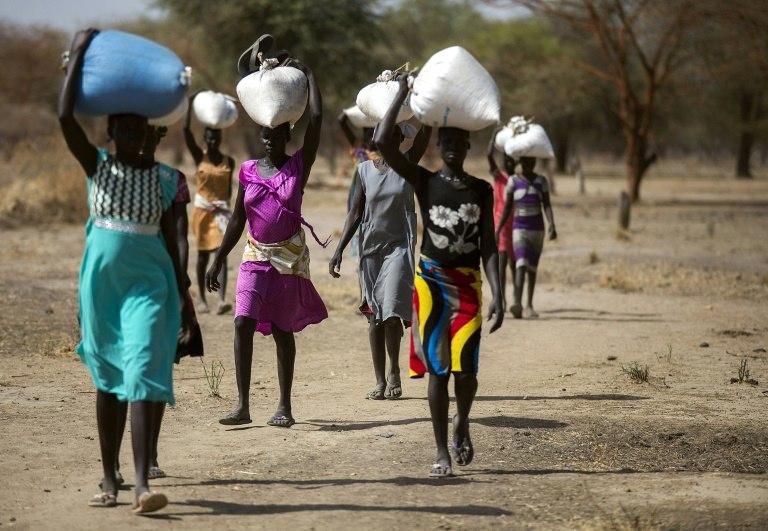The conflict has also heavily disrupted agriculture, sparking a major food crisis. In 2017 South Sudan endured four months of famine, which affected around 100,000 people. Here, women are shown carrying food aid on their heads