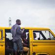 A Lagos 'Danfo' conveying people to their destination, 'Agbero' helps the driver.