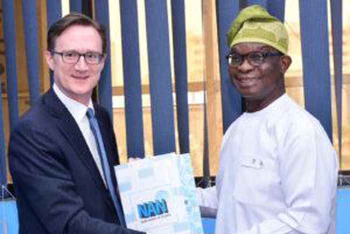 Managing Director of the News Agency of Nigeria (NAN), Buki Ponle (r) offering a souvenir of the agency to the new British High Commissioner to Nigeria, Mr Richard Montgomery (l) when the latter paid a courtesy call on the NAN MD in Abuja on Thursday, ...