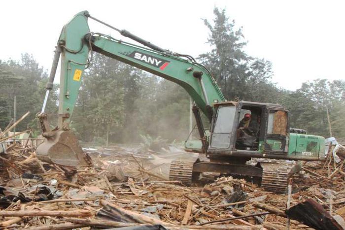 A bulldozer demolishing a building