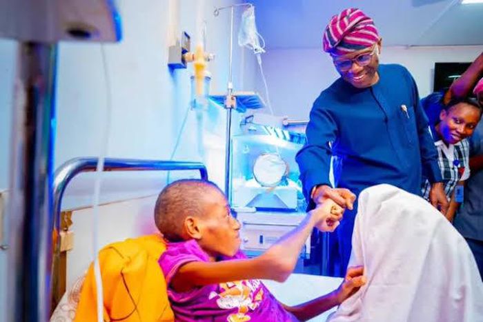 Lagos State governor, Babajide Sanwo-Olu, fistbumps boy with missing intestine, Adebola Akin-Bright [LASG]