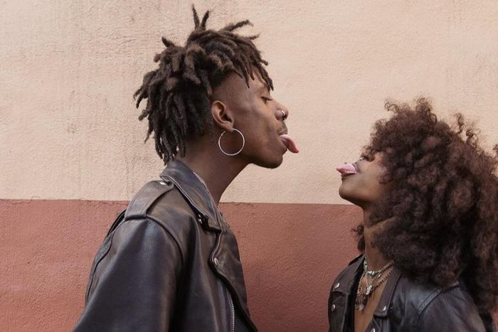 Young couple standing face to face and sticking out tongues [Image: Brian Jr Asare]