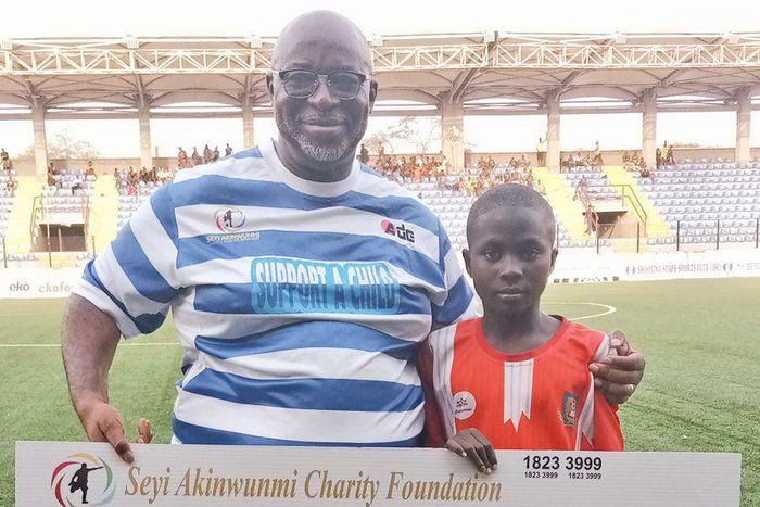 Seyi Akinwunmi presenting cheque to one of the beneficiaries