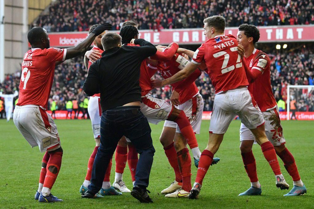 A supporter is tackled by stewards after confronting Nottingham Forest players