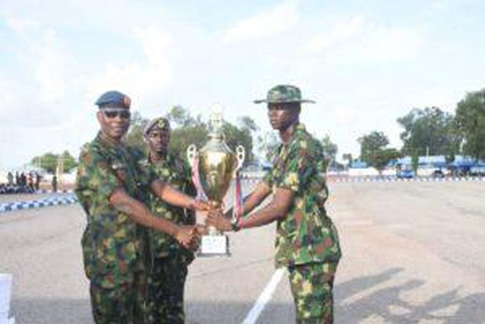 The Chief of Policy and Plans NAF Headquarters, AVM Soya Olatunde , presenting Trophy to Mi35 Champion Squadron, during the beating of the retreat of Basic Military Training Course 43/202 on Thursday in Kaduna