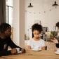 Black parents lecturing upset daughter at table [Credit: Monstera Production]