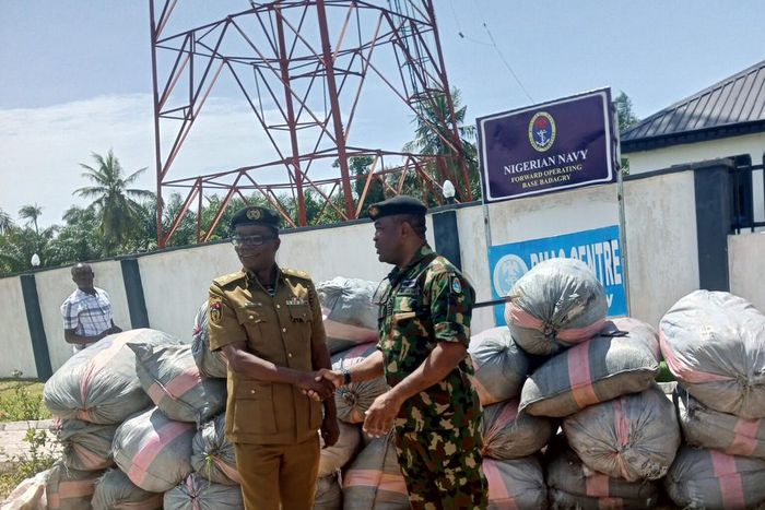 Commanding Officer, FOB NN Badagry, handing over the 27 sacks of cannabis sativa to NDLEA commander in Badagry (Credit: NAN)